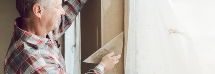 Person verputzt Wand mit Kelle